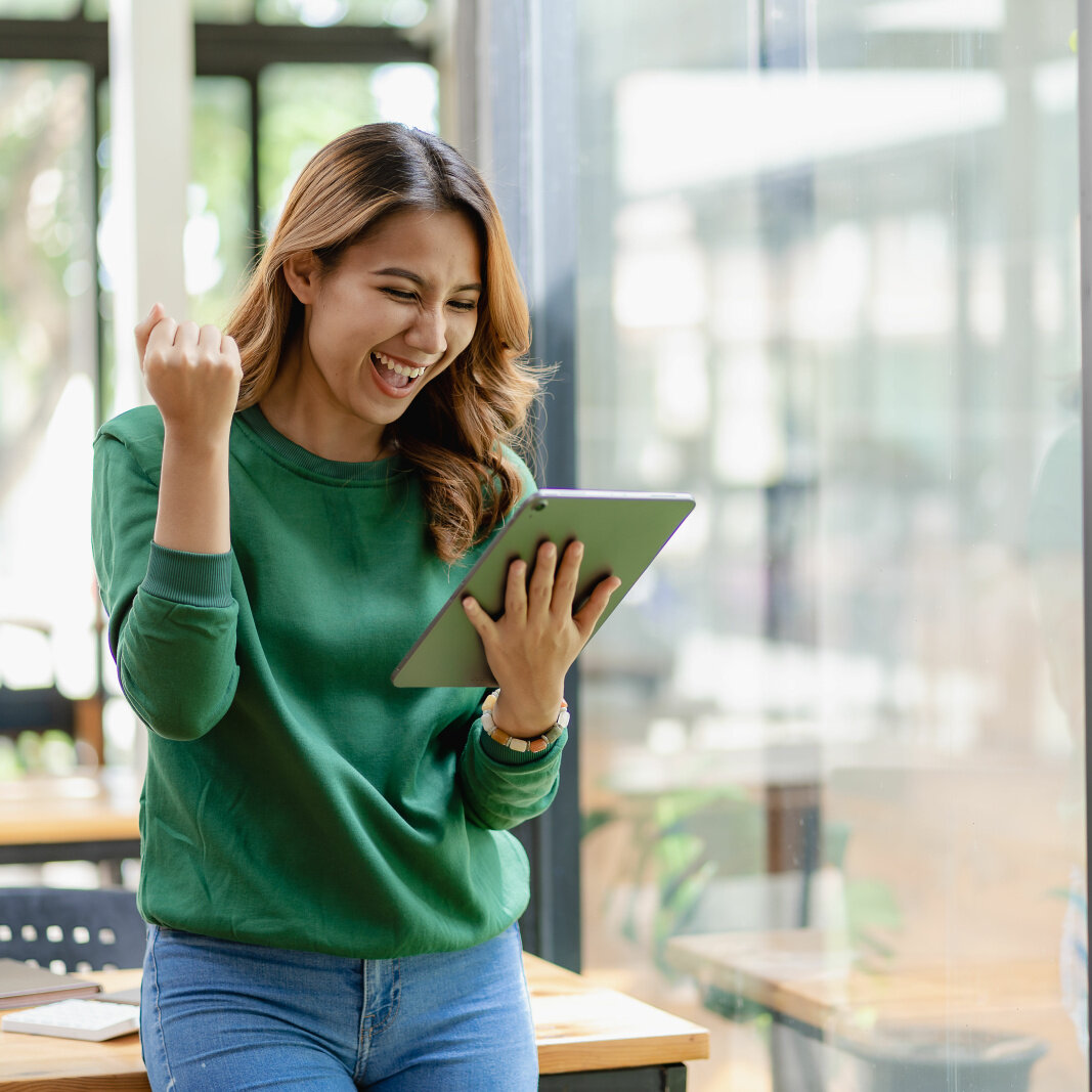 Woman looks at her tablet and smiles